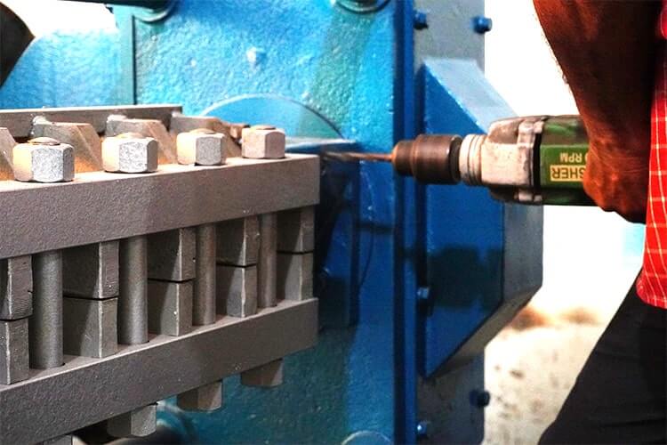 a person using a drill to drill a piece of metal
